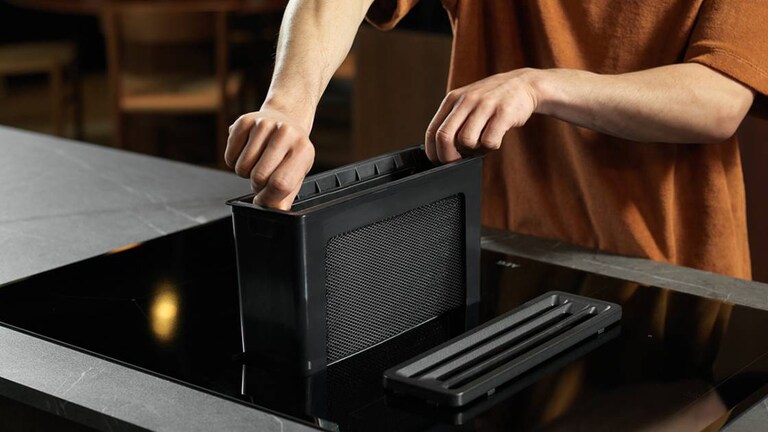 Insertion manuelle du filtre de la hotte de cuisine